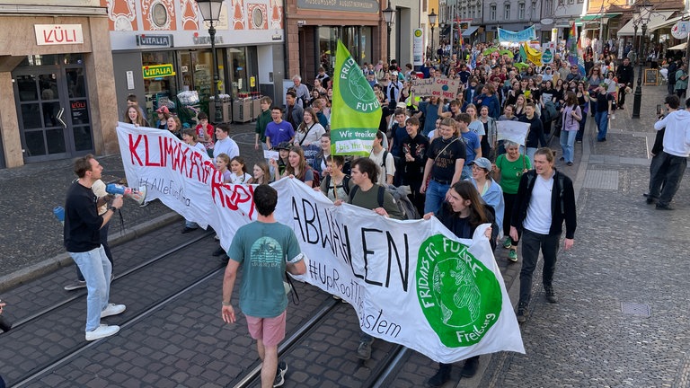 Teilnehmende der Demonstration von Fridays For Future ziehen durch die Innenstadt von Freiburg.