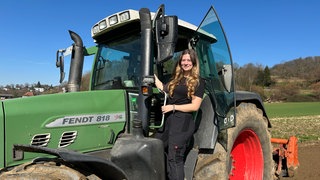 Landwirtin Lisa Dinger steht auf ihrem Traktor