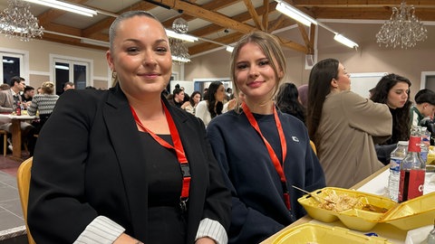 Angelina sitzt gemeinsam mit Freunden zum Fastenbrechen am Tisch. Sie ist eine der Freiwilligen.