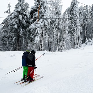 Zwei Skifahrer in einem Schlepplift im Schwarzwald.