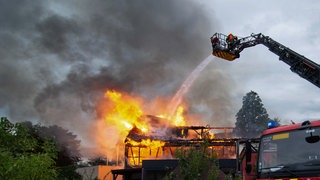 Feuerwehrleute löschen einen Brand in einer Ferienunterkunft.