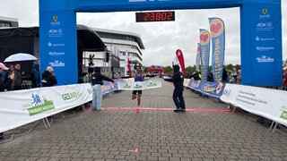 Enoque Buchegger überquert als Erster im Halbmarathon mit einer Zeit von 1:08:34 die Ziellinie.
