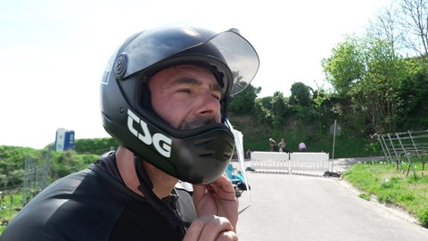Ein Mann zieht einen Helm an.