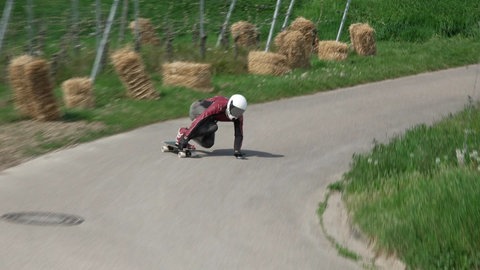 Ein Downhill-Skateboarder fährt eine Kurve.