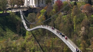 Bei sonnigem Wetter trauten sich die ersten Besucherinnen und Besucher auf die neue Hängebrücke in Rottweil. Die "Neckarline" verbindet den Aufzugtestturm und die Innenstadt miteinander.