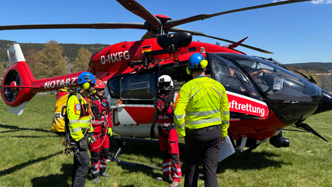 Rettungskräfte von DRF Luftrettung und Bergwacht vor dem Rettungshubschrauber in Schluchsee.