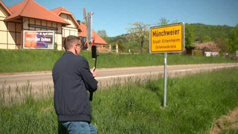 Patrik Lehmann am Ortsschild von Münchweier (Ortenaukreis. Er ist der Instagram-Star vom Dorf.