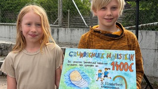 Die Grundschüler Clara und Valentin freuen sich, dass sie mit ihrer Spende schwangeren Frauen in Not helfen können.