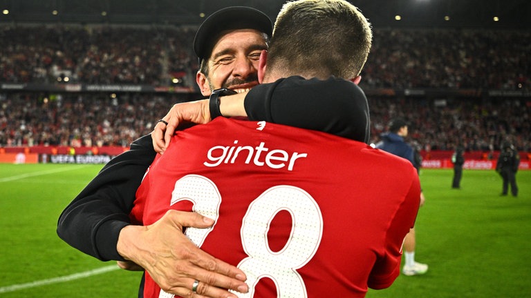 Pures Glück: SC-Trainer Julian Schuster genießt den Triumph an der Brust von Matthias Ginter