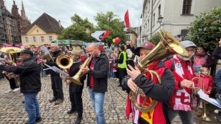 Musizieren und Singen - Fans und Blasmusikgruppen feiern den SC Freiburg auf dem Münsterplatz mit einem musikalischen Flashmob