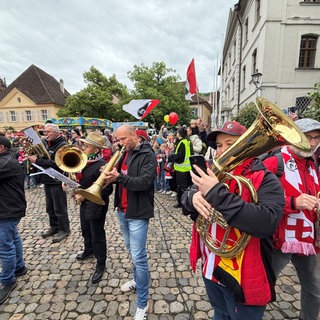 Musizieren und Singen - Fans und Blasmusikgruppen feiern den SC Freiburg auf dem Münsterplatz mit einem musikalischen Flashmob
