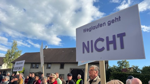 Auf einem Schild steht "Weglaufen geht nicht". Protest gegen Bürgermeister in Wutach.
