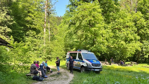 Wanderer und ein Fahrzeug der Bergwacht im Schwarzwald. Anhand der neuen Rettungssektorenschilder kann die Bergwacht im Notfall genauer einschätzen, wie sie am Schnellsten zur verletzten Person gelangt.