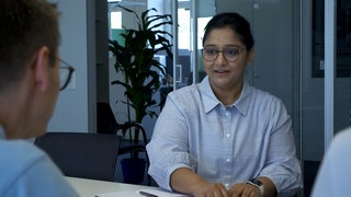 Eine Frau sitzt an einem Tisch.