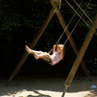Zwei Kinder auf einer Schaukel. Am Waldspielplatz von Denzlingen.