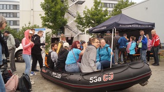 Besucherinnen und Besucher in einem Schlauchboot der Wasserschutzpolizei