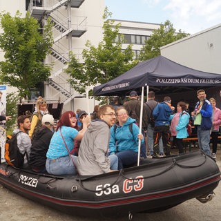 Besucherinnen und Besucher in einem Schlauchboot der Wasserschutzpolizei