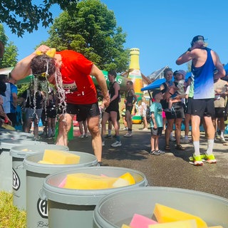 Sport bei Hitze: Ein Mann kühlt sich den Kopf mit Wasser