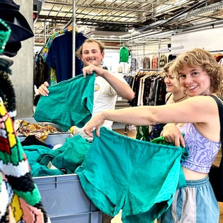 Eine Freundesgruppe sucht in einem der Freiburger Secondhand-Läden nach Kleidung. 