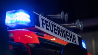 Ein Einsatzfahrzeug der Feuerwehr steht mit Blaulicht bei der Feuerwache (Symbolbild).