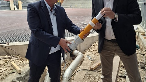 Oberbürgermeister Jürgen Roth mit KEB-Betriebsleiter und KEB-Geschäftsführer Gregor Gülpen beim befüllen der Zeitkapsel.