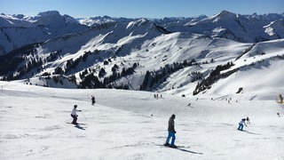 Skifahrer fahren auf der Skipiste in Damüls.