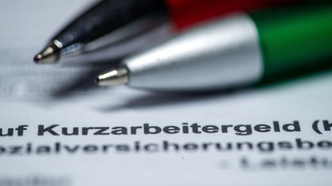 Zwei Kugelschreiber liegen auf einem Antragsformular für Kurzarbeitergeld