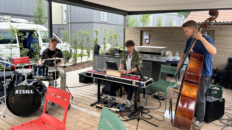 Die drei Musiker der Jazzformation "elt Trio" stehen mit ihren Instrumenten auf der SWR-Bühne des "Talk im Grünen" in Wangen