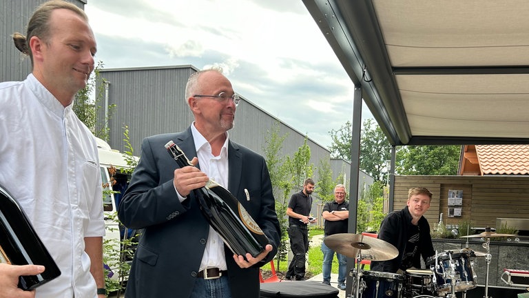 Sterneköche Julian Karr und Jochen Fecht stehen mit übergroßen Bierflaschen auf der Bühne des SWR auf der Landesgartenschau in Wangen