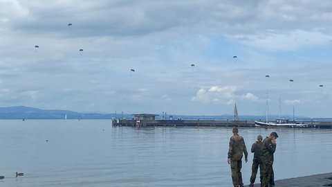 Fallschrimspringerinnen und Fallschirmspringer der Bundeswehr üben im Bodensee vor Langenargen.