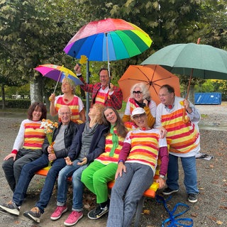 Menschen sitzen am Bodensee in Konstanz auf der Humorbank. Die Bank am Seeufer soll nicht nur zum Ausruhen, sondern auch zum miteinander Lachen einladen. Die Bank ist laut den Initiatoren die erste Humorbank Deutschlands - vielleicht sogar der Welt.