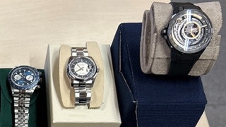 Fünf Armbanduhren liegen auf einem Tisch
