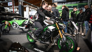 Eine Frau sitzt auf einem Motorrad bei der Messe "Motorradweld Bodensee"