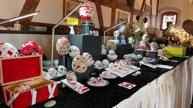 Bunte Ostereier mit filigranen Goldverzierungen auf einem Marktstand in Wangen im Allgäu.