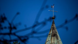 Ein Kreuz auf dem Dach einer Kirche. In der Diözese Rottenburg-Stuttgart werden am Sonntag Kirchengemeinderäte gewählt. 
