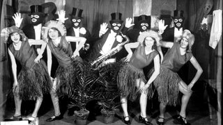 Die gemischte Gruppe "The Bodan Jazz-Rhythmicians" Frauen und Männer verkleidet in Smoking und Zylinder und Kleidern und Basthüten