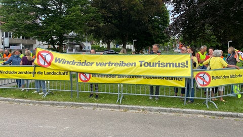 Vor dem Kongresszentrum in Weingarten protestieren Menschen gegen den Windpark im Altdorfer Wald