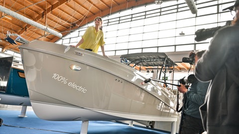 Ein Model präsentiert ein neues Elektroboot auf der Interboot 2024 in Friedrichshafen