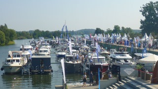 Motorboote liegen dicht an dicht am Ufer eines Binnengewässers. Laut der Studie beeinträchtigt die Freizeitschifffahrt die deutschen Binnenseen zunehmend.