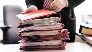 Ein Oberstaatsanwalt bindet einen Stapel Gerichtsakten zusammen. (Symbolbild)