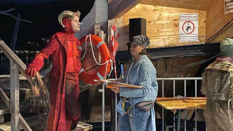 Solisten, Chor, Stuntleute, Maskenbildnerinnen und Regieassistentinnen wirbeln unter der Seebühne bei "Der Freischütz" der Bregenzer Festspiele.