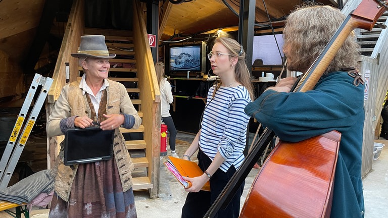 Solisten, Chor, Stuntleute, Maskenbildnerinnen und Regieassistentinnen wirbeln unter der Seebühne bei "Der Freischütz" der Bregenzer Festspiele.