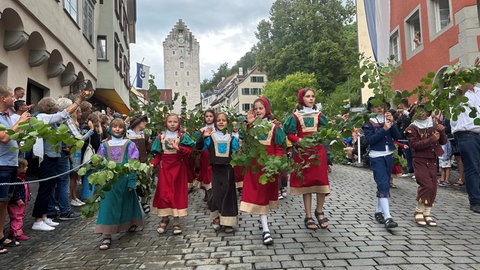 Kinder nehmen beim Rutenfest am historische Festzug teil.