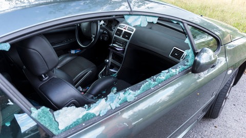 Ein eingeschlagenes Seitenfenster eines geparkten Autos (Symbolbild). In Laupheim gibt es mehr als ein Dutzend solcher Autoaufbrüche mit Gullydeckeln und Steinen.