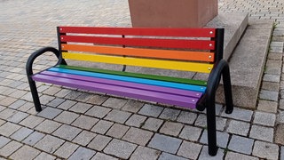 Die Regenbogenbank vor einer Kirche in Bad Waldsee wird immer wieder Ziel von Vandalismus.