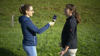 SWR-Reporterin Viktoria Clausnitzer interviewt Landwirtin Magdalena Zintl, die auf der Adelegg 40 Ziegen hält.  