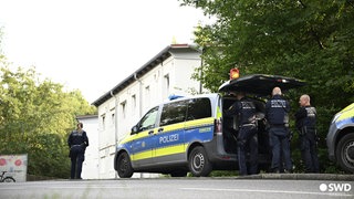 Polizisten stehen in der Nähe des Flüchtlingsheims.