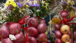 Mit Trockenblumen geschmückte Zwiebeln, zum Zopf gebunden. Beim Büllefest auf der Höri in Moos dreht sich alles um die Zwiebel.