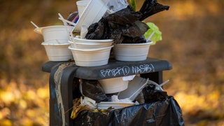Ein überquellender öffentlicher Mülleimer. In Konstanz hat die Müllmenge dank Verpackungssteuer abgenommen.
