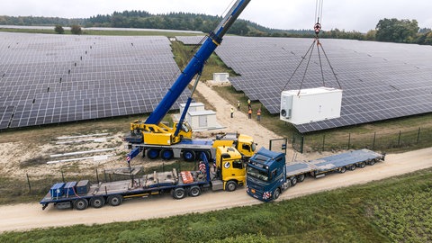 Ein Batteriespeicher hängt an einem Kran: Er wird im Solarpark Aach zum Einsatz kommen.